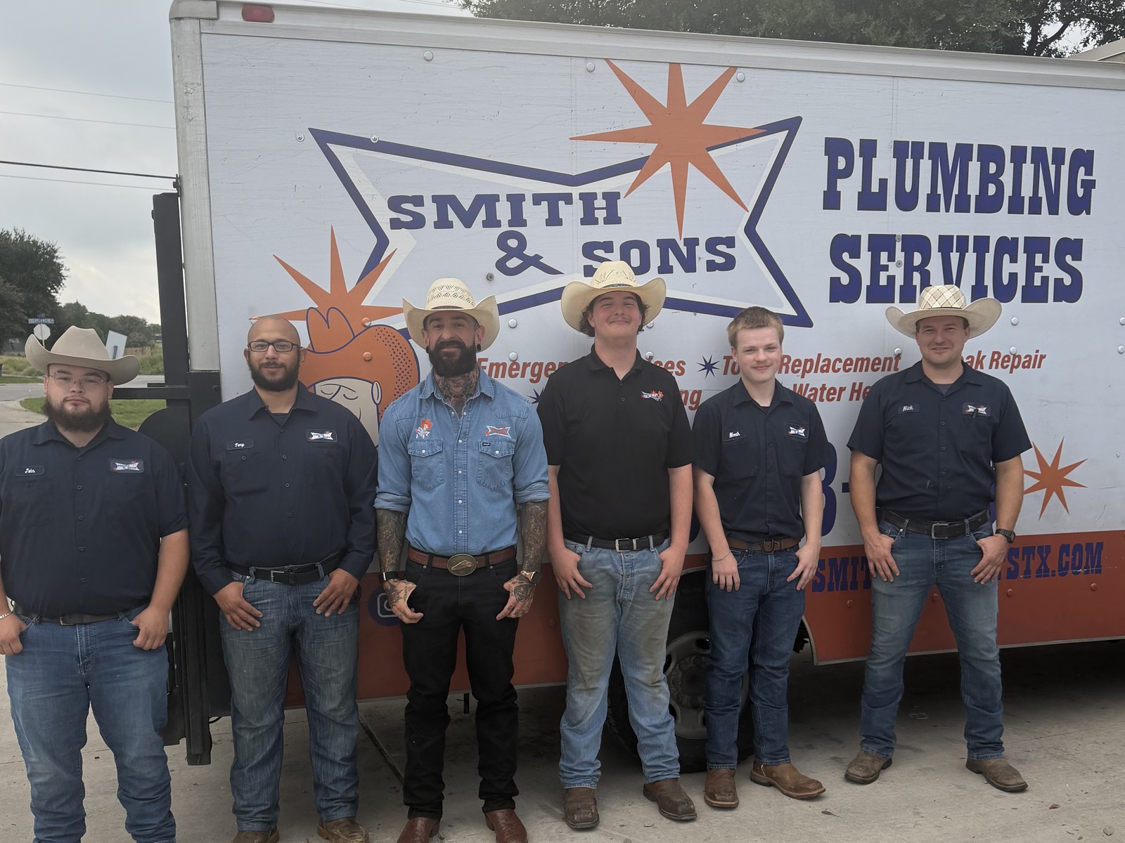 Smith & Sons Plumbing team standing in front of a company service truck